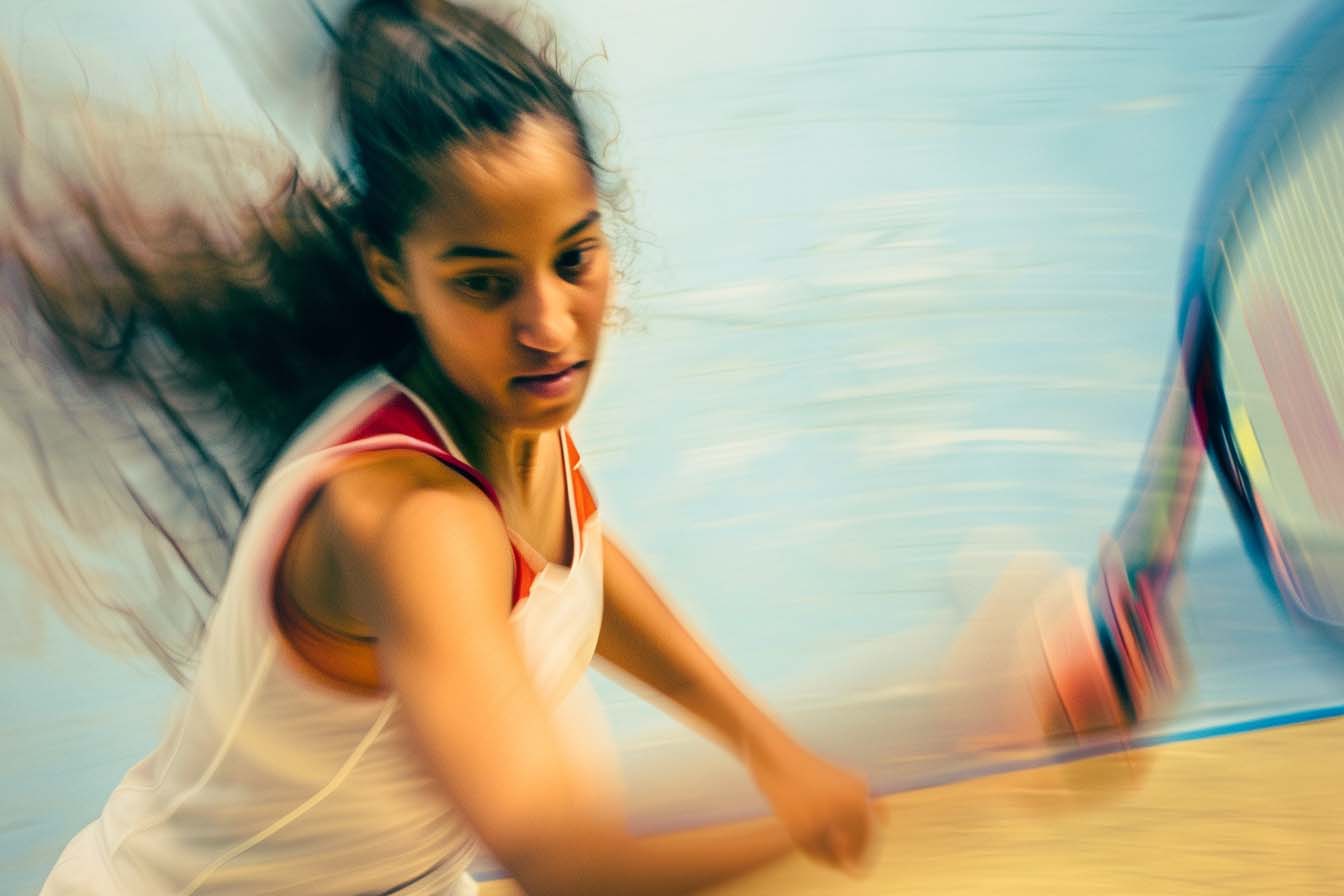 Woman playing squash with motion blur